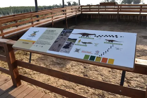 Bilingual signage panel with dinosaur footprints, QR code and site map, Dinosaur Route